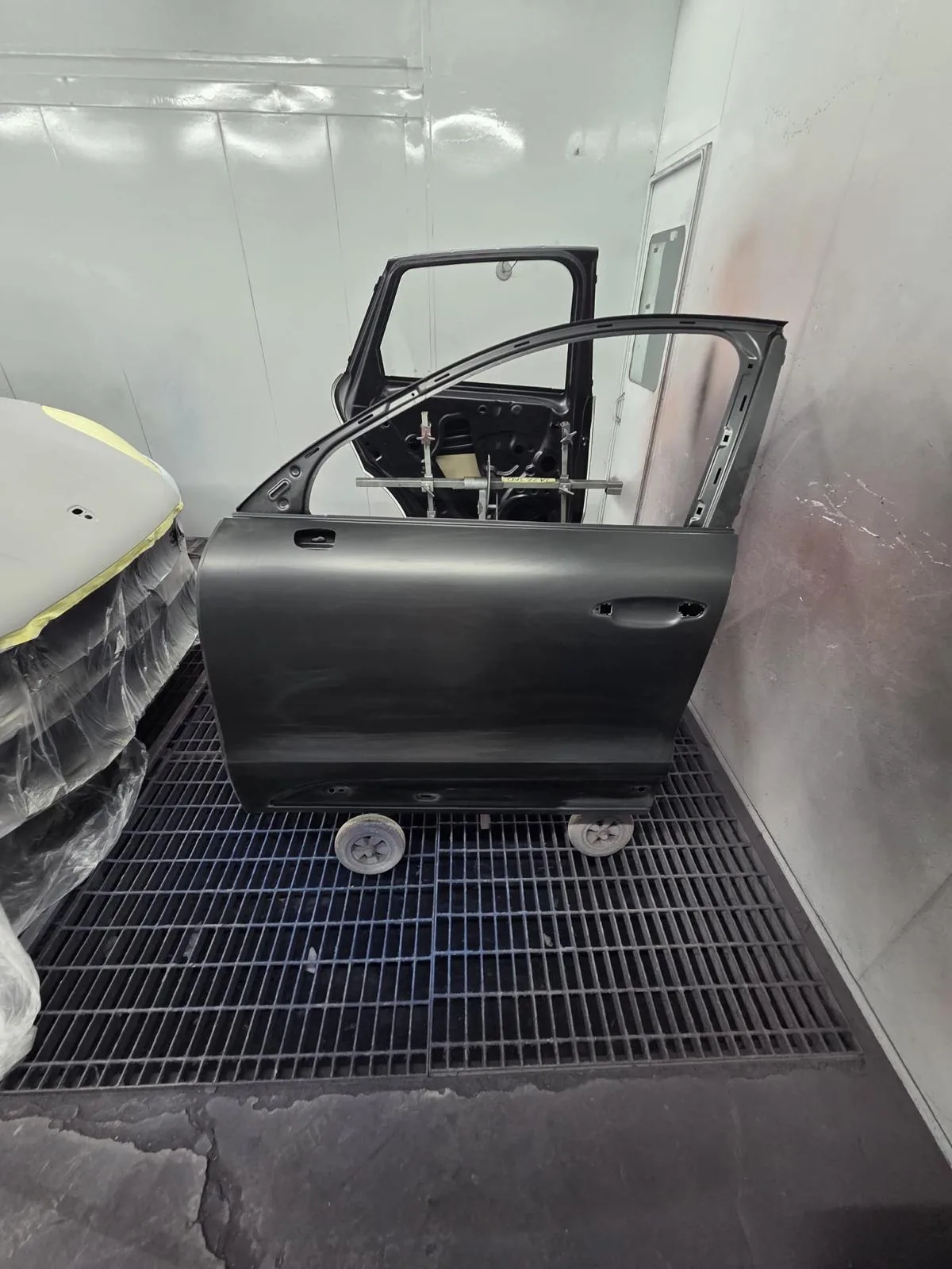 A detached door prepared for refinishing in the spray booth.