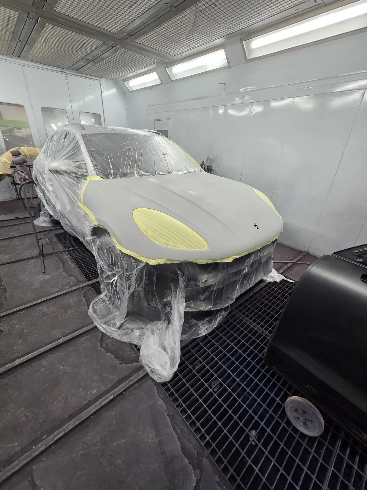 Front bodywork masked and prepared for paintwork in the spray booth.