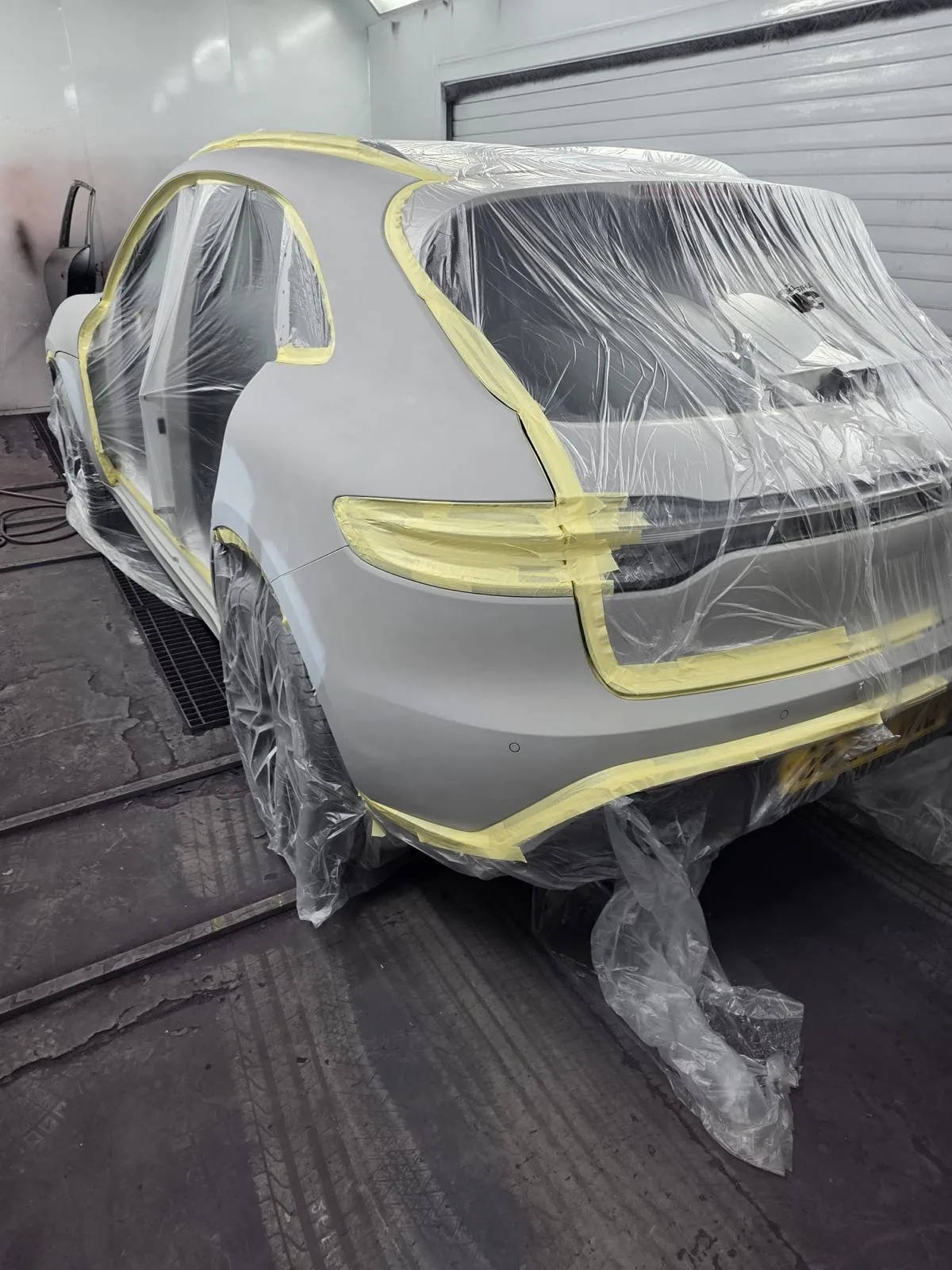 Rear panels prepared with adjacent areas protected before painting.